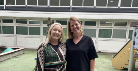 Abi Larson and Amy Wright, Speech and Language Therapist and Occupational Therapist, standing together and smiling at the Words First hub, dedicated to providing support for children and young people using Augmentative and Alternative Communication (AAC).